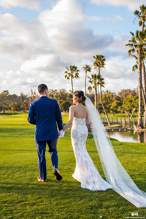  bride in a white gown with a lace strapless neckline and the groom in a blue suit 