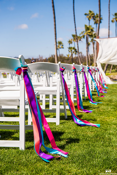  white chairs with colorful linen 