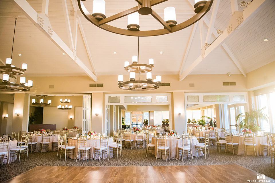 indoor reception space with white linens and hanging chandeliers