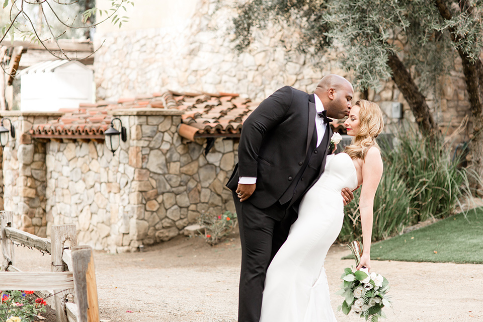 Oak-Meadows-Shoot-groom-dipping-bride-bride-in-a-white-strapless-lace-gown-groom-in-a-black-tuxedo-with-a-black-bow-tie