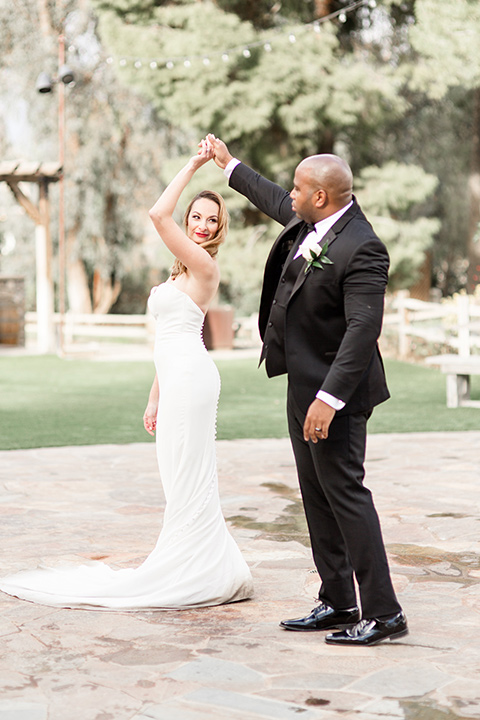 Oak-Meadows-Shoot-groom-twirling-bride-bride-in-a-strapless-gown-with-lace-detailing-groom-in-a-black-notch-lapel-tuxedo-with-a-black-bow-tie