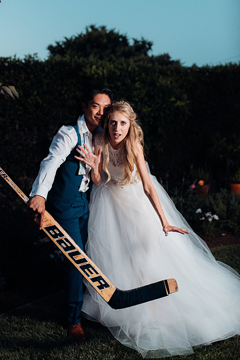 orange-county-wedding-bride-and-groom-under-blue-window-awning-bride-in-a-two-piece-lace-ballgown-groom-in-a-brighter-blue-suit-with-a-flowal-bowtie