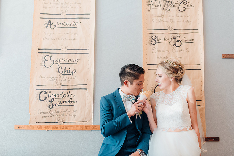 orange-county-wedding-bride-in-groom-sharing-ice-cream-bride-in-a-two-piece-lace-ballgown-groom-in-a-brighter-blue-suit-with-a-flowal-bowtie