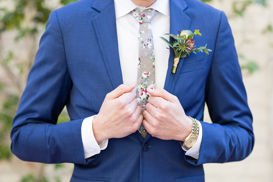 the groom look with a cobalt blue suit and light grey floral neck tie 