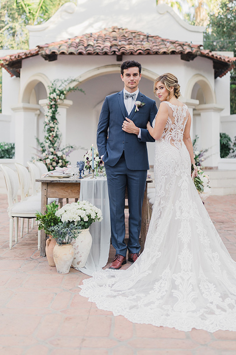 rancho-las-lomas-wedding-bride-and-groom-outside-by-gazeebo-space-bride-in-lace-with-dress-groom-in-blue-suit-with-grey-bowtie