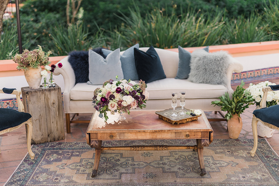 rancho-las-lomas-wedding-outdoor-furniture-décor-with-purple-accented-pillows-and-wooden-tables