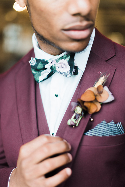 rock-n-roll-wedding-style-close-up-on-menswear-in-a-deep-burgundy-suit-with-floral-bow-tie