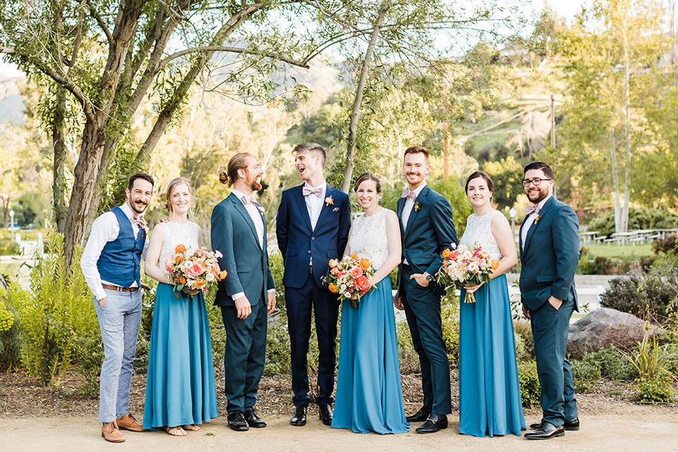  groomsmen in blue suits and groomsladies in blue skirts and cream tops