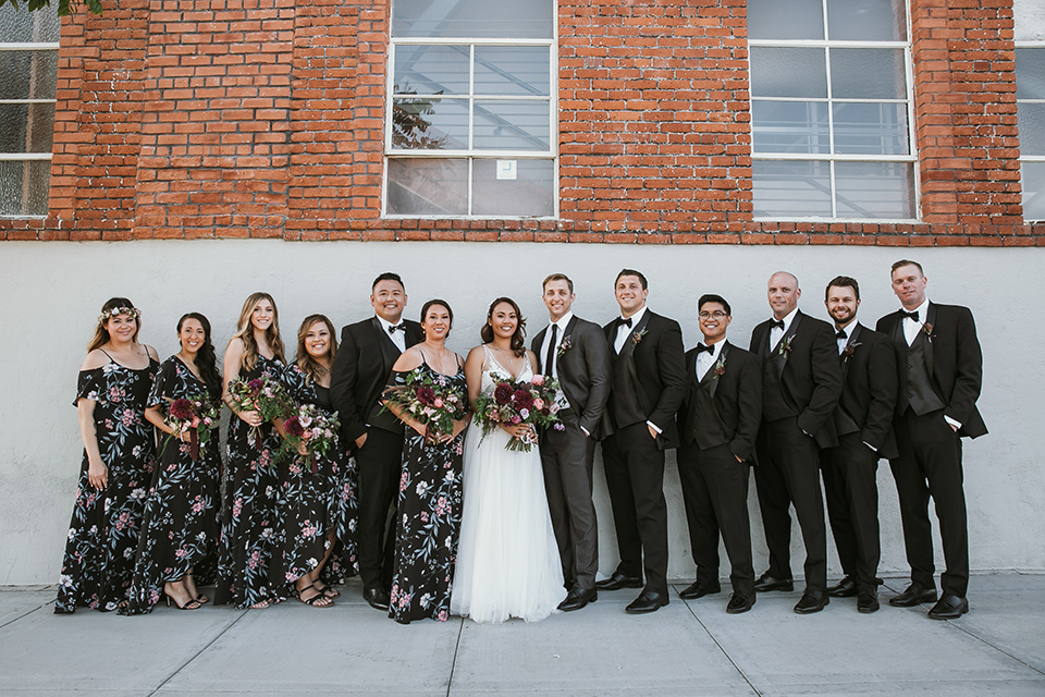  bridesmaids in floral long gowns and bridesman in a black tuxedo