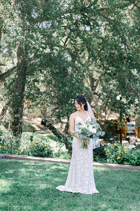 Circle-Oak-ranch-wedding-bride-standing-bride-in-lace-form-fitting-gown-with-thin-straps