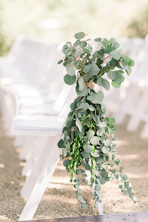 Circle-Oak-ranch-wedding-ceremony-chairs-with-greenry-on-it