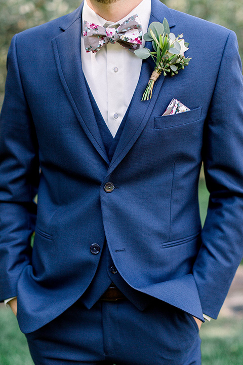 Circle-Oak-ranch-wedding-groom-close-up-in-a-cobalt-suit-with-a-floral-bowtie