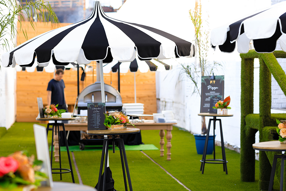 Friar-Tux-Summer-Bash-bar-outdoor-space-with-green-astro-turf-everywhere-and-modern-black-and-white-umbrellas