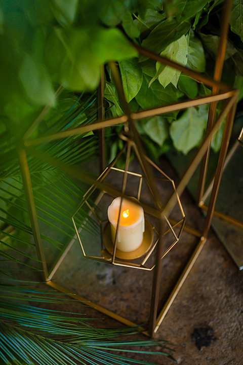 candle decor in wire casing with surrounded by greenery