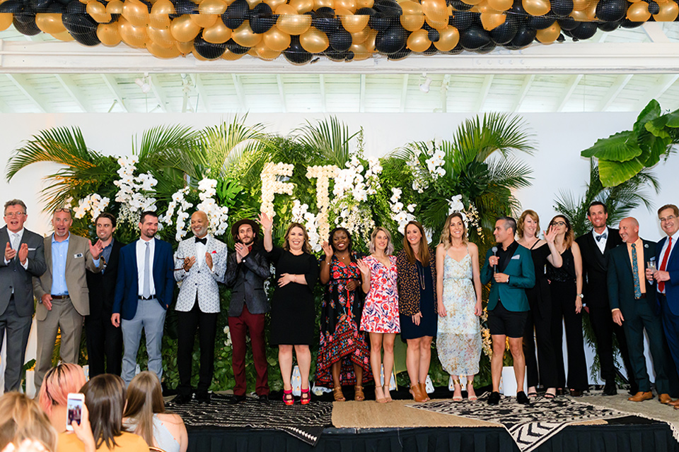 Friar Tux employees, friends, and family wave to the camera in the los angeles venue