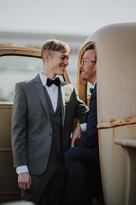 Sunset-Cliffs-Shoot-grooms-in-truck-one-groom-in-a-grey-suit-and-one-groom-in-a-navy-suit