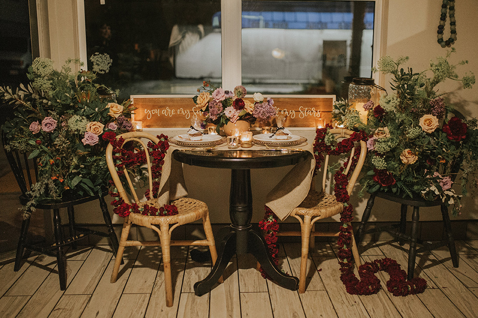 Sunset-Cliffs-Shoot-table-set-up-with-wooden-chairs-and-gold-decor