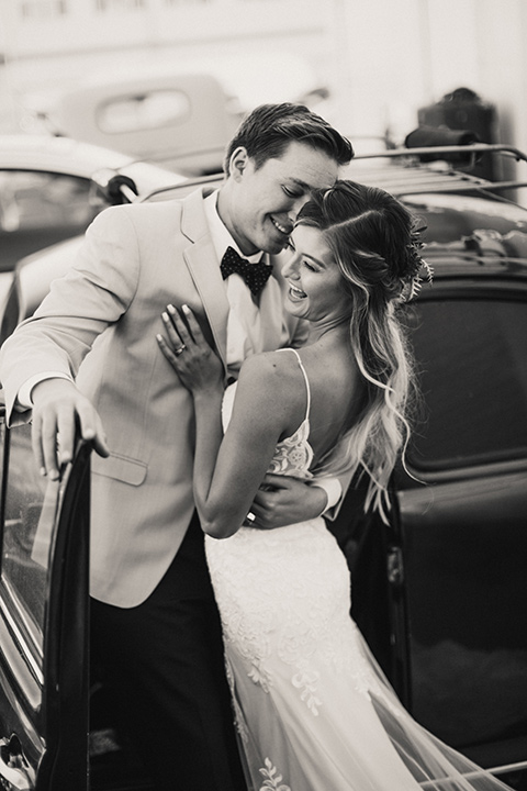 Sunset-Cliffs-Elopement-bride-and-groom-laughing-bride-in-a-lace-white-gown-with-thin-straps-groom-in-a-tan-suit-coat-with-black-pants-and-black-bow-tie