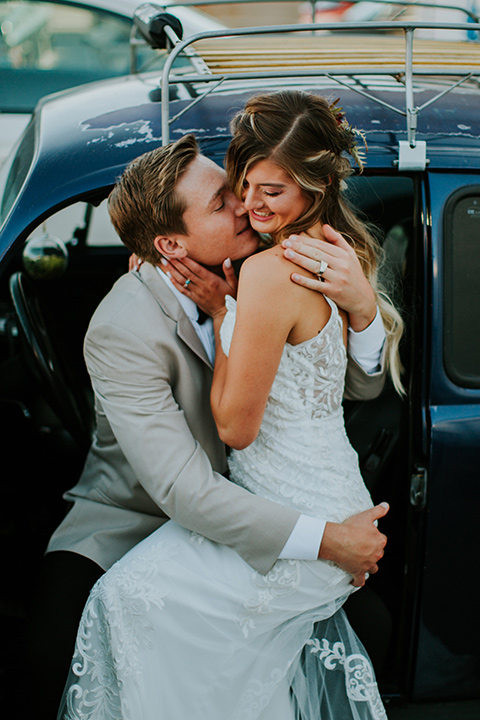 Sunset-Cliffs-Elopement-bride-and-groom-sitting-in-car-bride-in-a-lace-white-gown-with-thin-straps-groom-in-a-tan-suit-coat-with-black-pants-and-black-bow-tie