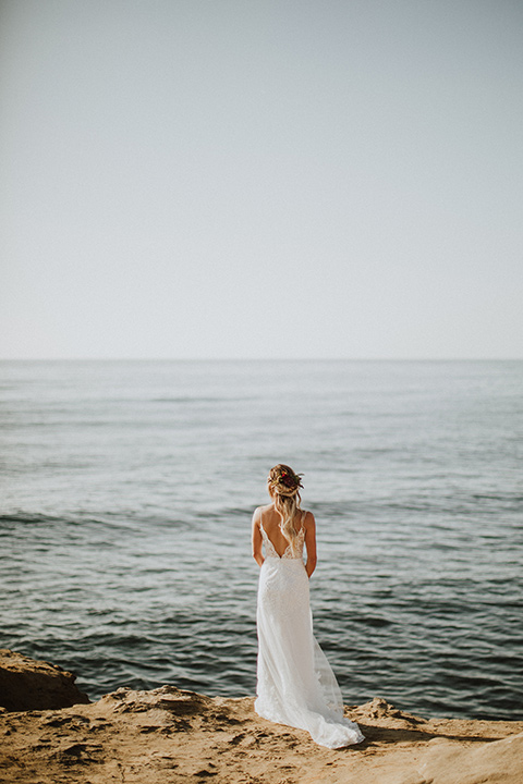 Sunset-Cliffs-Elopement-bride-looking-at-ocean-in-a-lace-white-gown-with-thin-straps