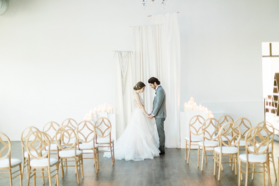 The-1912-Shoot-bride-and-groom-at-ceremony-groom-in-a-grey-suit-and-ivory-bow-tie-bride-in-a-tulle-ballgown-with-straps