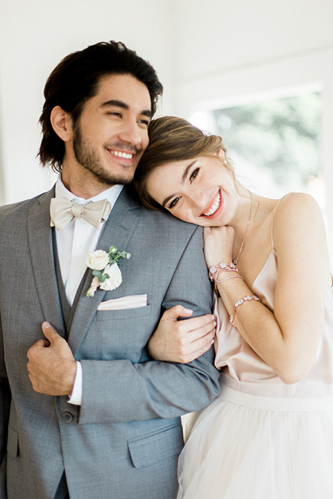 The-1912-Shoot-bride-and-groom-close-groom-in-a-grey-suit-with-an-ivory-bow-tie-bride-in-a-tulle-ballgown-with-a-sweetheart-neckline