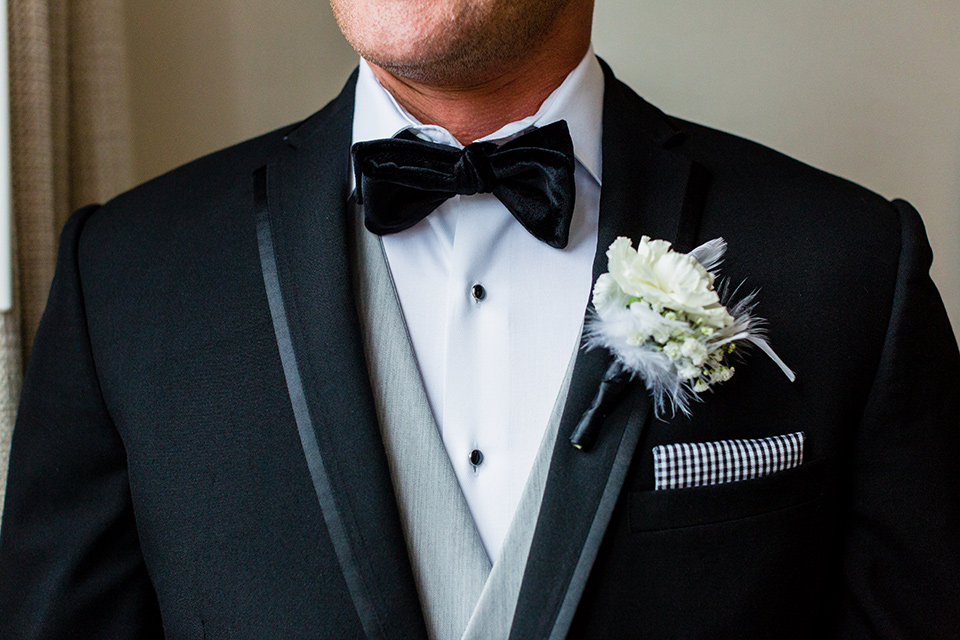 wedding groom style up close in a black framed tuxedo jacket with a light grey pant and light grey vest 