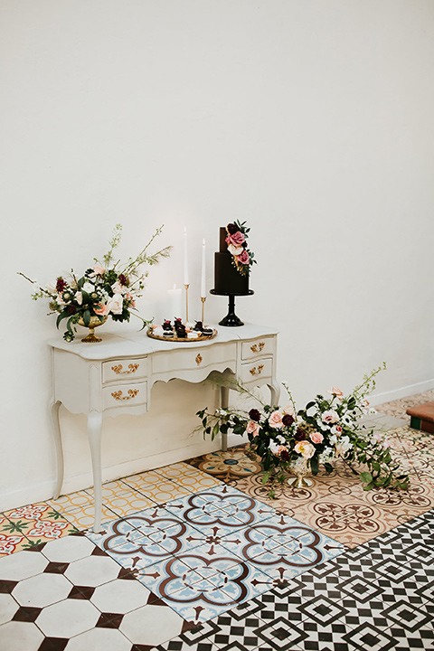 black cake with fun florals on a white vintage table