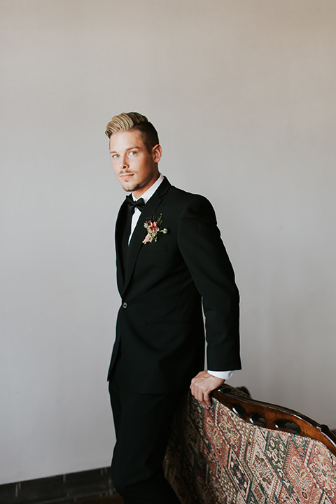 groom in a black suit with a black long tie