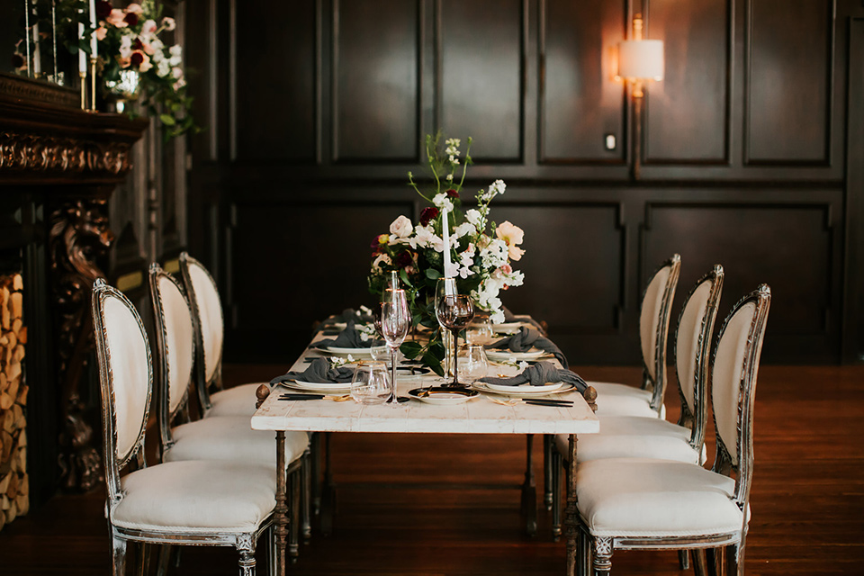 black table with white chairs and simple floral centerpiece design