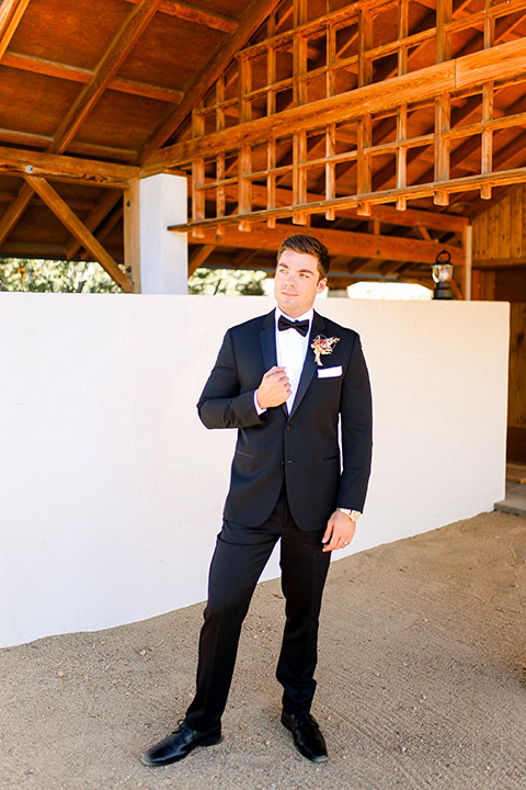 Groom in a black tuxedo with a black bow tie