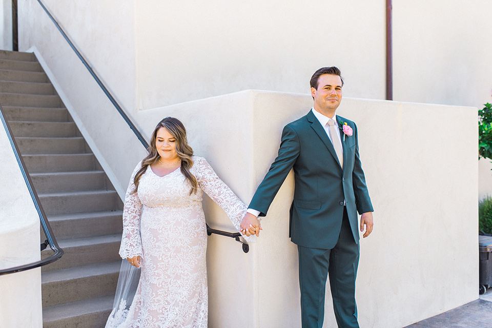 Topa-Winery-Wedding-bride-and-groom-first-look-bride-in-a-bohemian-lace-gown-with-long-flowing-sleeves-groom-in-a-green-suit-with-a-tan-long-tie