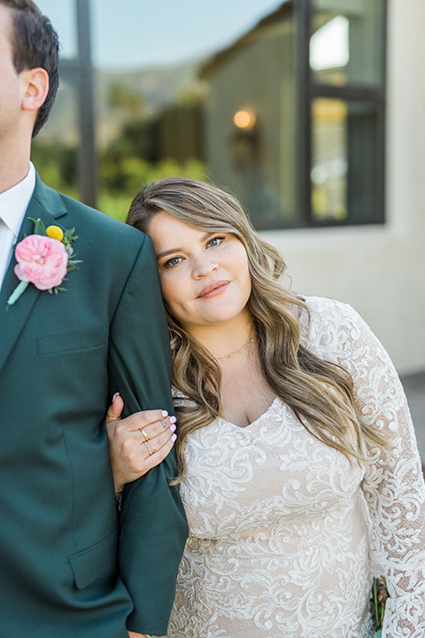 Topa-Winery-Wedding-close-up-on-couple-bride-in-a-lace-bohemian-style-gown-with-flutter-sleeves-groom-in-a-green-suit-with-a-tan-long-tie-with-brown-shoes