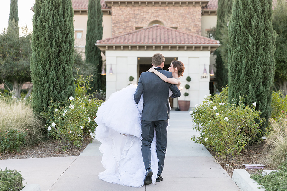 Vellano-Country-Club-groom-holding-bride-bride-in-a-ballgown-with-her-hair-up-groom-in-a-charcoal-grey-tuxedo-with-a-black-bow-tie