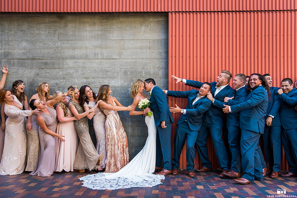 bride and groom being pulled in different directions by groomsmen and bridesmaids