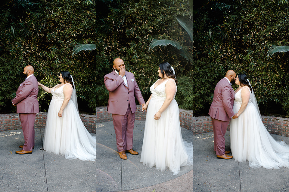 The groom in a pink suit and the bride in a lace flowing gown