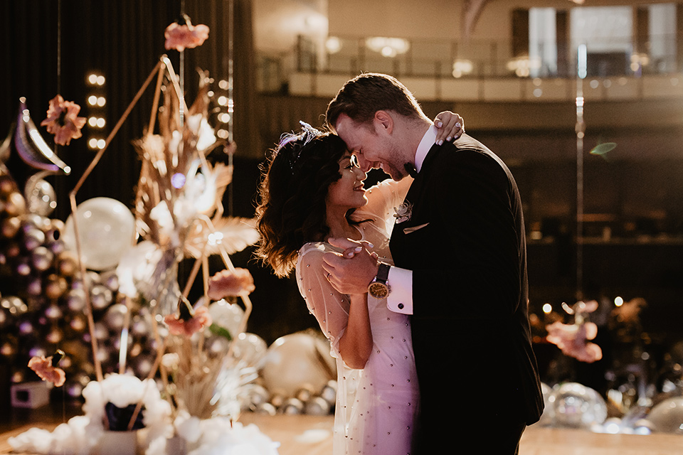 The-Yost-Theatre-bride-and-groom-dancing-bride-in-a-silk-modern-gown-with-star-accessories-and-groom-in-a-velvet-black-tuxedo