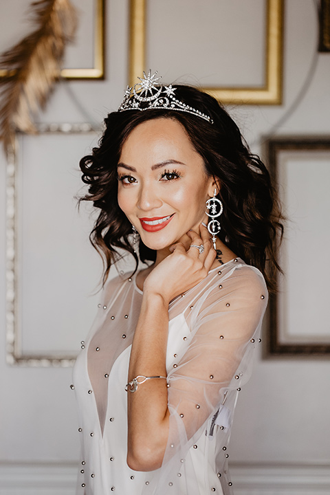 The-Yost-Theatre-bride-smiling-towards-camera-bride-in-a-modern-gown-with-jeweled-detailing-groom-in-a-velvet-tuxedo