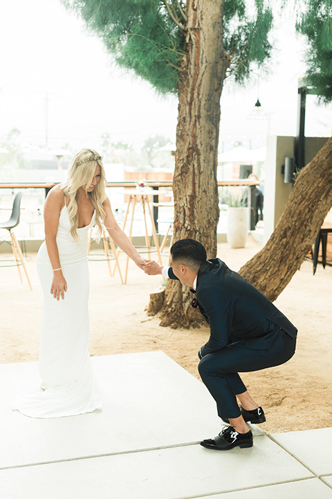 the-lautner-compound-wedding-bride-and-groom-first-look-groom-bending-over-in-surprise-the-bride-wore-a-formfitting-lace-gown-with-strap-groom-wore-a-blue-shawl-lapel-tuxedo