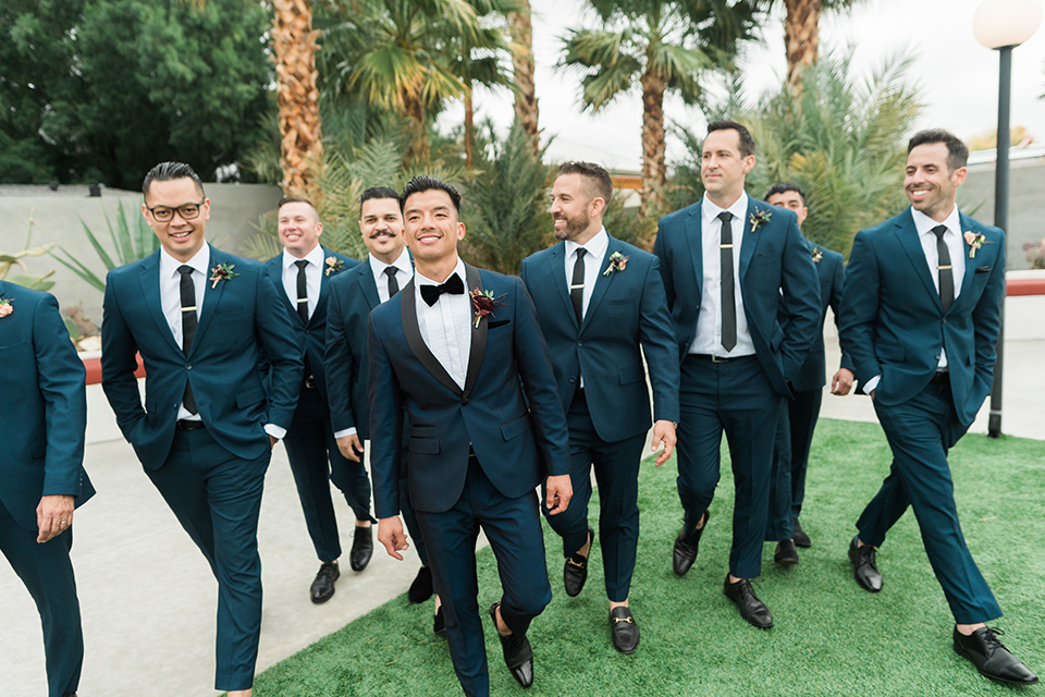 the-lautner-compound-wedding-groomsmen-walking-in-blue-suits-and-groom-in-a-dark-blue-shawl-lapel-tuxedo