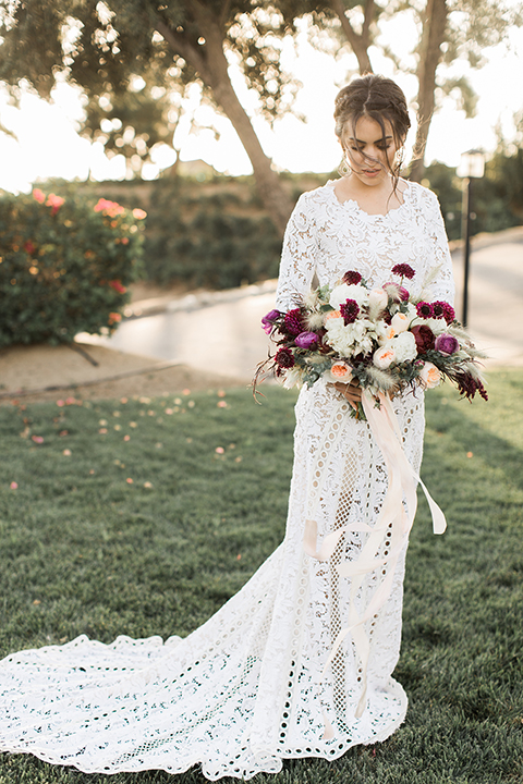 Temecula-outdoor-wedding-at-callaway-winery-bride-holding-bouquet-bride-in-a-lace-bohemian-dress