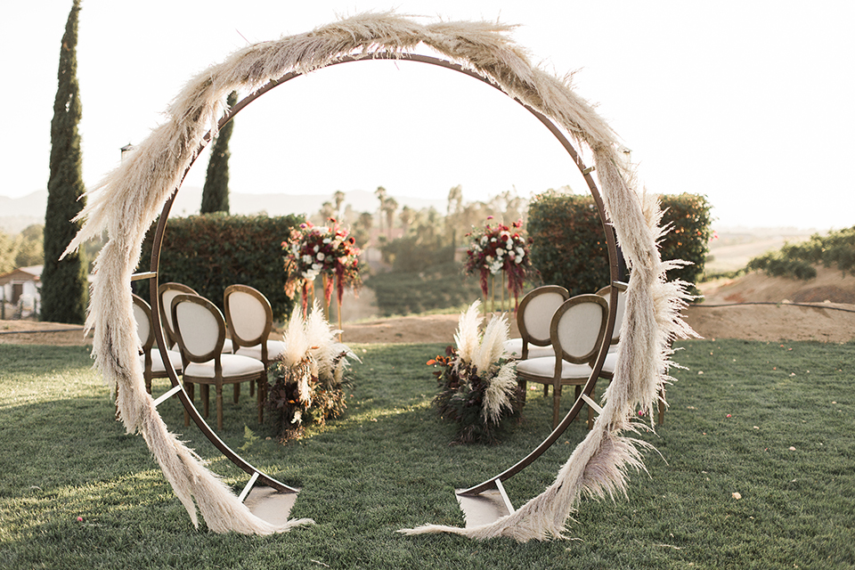 Temecula-outdoor-wedding-at-callaway-winery-ceremony-set-up-feather-grass-bohemian-style-archway