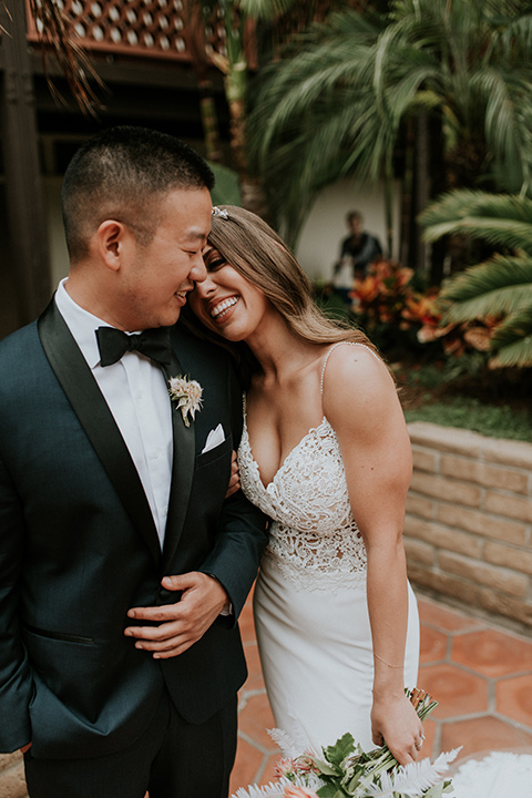 la-jola-shores-hotel-wedding-bride-resting-head-on-groom-bride-in-a-silk-fitted-gown-with-straps-groom-in-a-dark-blue-tuxedo