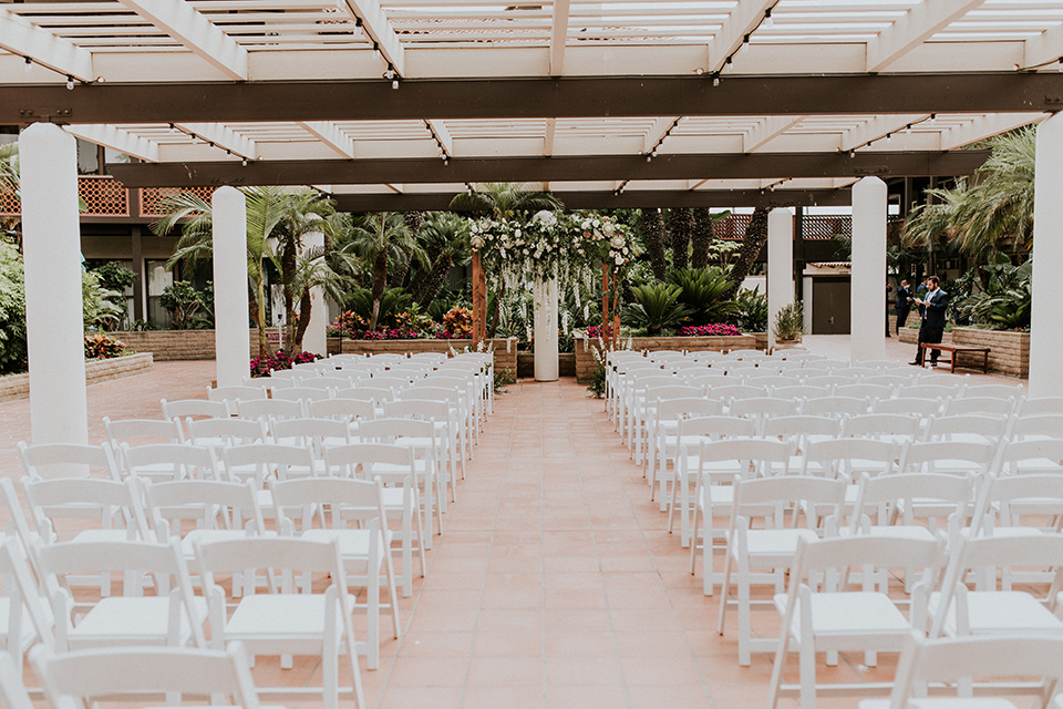 la-jola-shores-hotel-wedding-ceremony-set-up-with-white-chairs-and-a-wooden-archway