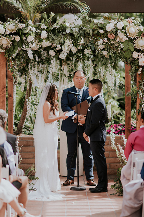 la-jola-shores-hotel-wedding-ceremony-bride-in-a-satin-gown-with-a-silver-bodice-and-straps-groom-in-a-navy-tuxedo-and-black-bow-tie