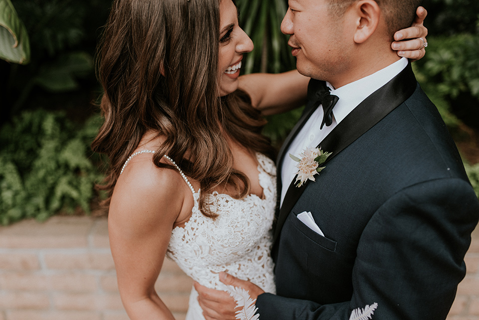 la-jola-shores-hotel-wedding-close-up-on-bride-and-groom-bride-in-a-formfitting-satin-dress-with-straps-groom-in-a-navy-tuxedo-with-black-shawl-lapel