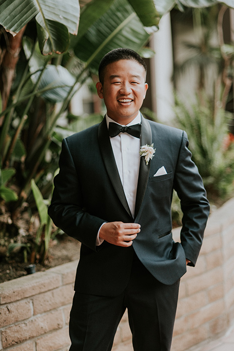 la-jola-shores-hotel-wedding-groom-smiling-at-camera-in-a-dark-blue-tuxedo-with-black-trim