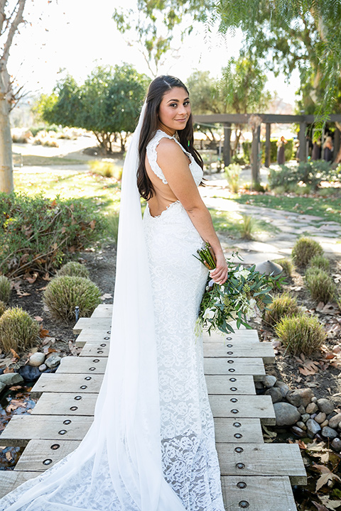 gallway-downs-wedding-bide-looking-at-camera-in-a-lace-formfitting-dress-with-a-high-neckline-and-keyhole-back