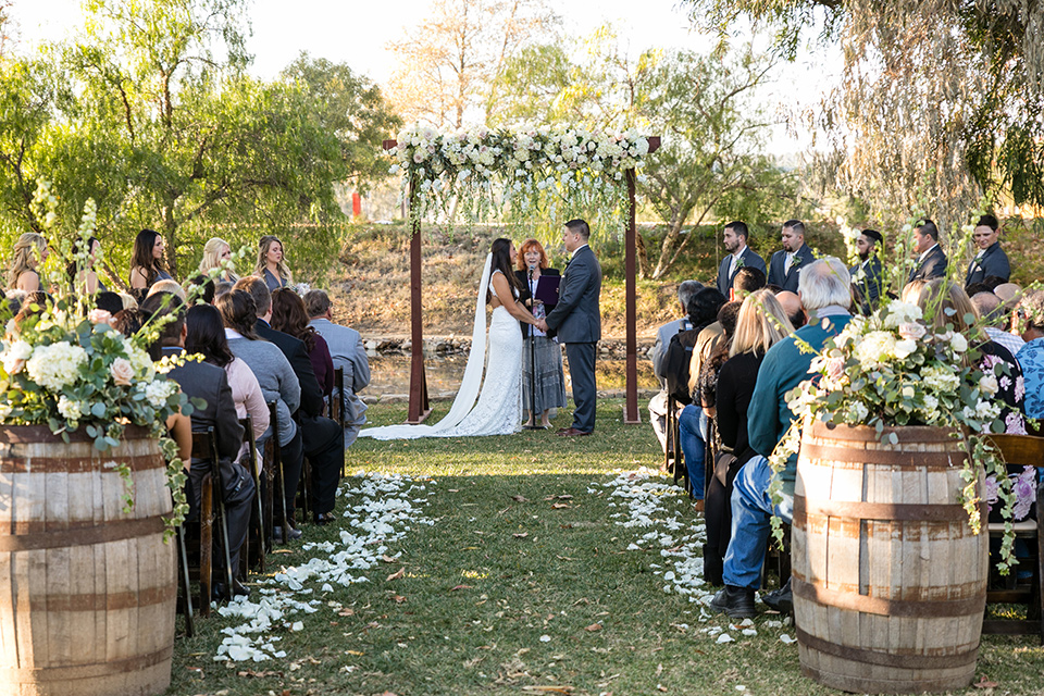 gallway-downs-wedding-ceremony-bride-in-a-lace-form-fitting-gown-with-a-high-neckline-and-keyhole-back-groom-in-a-charcoal-tux-withan-ivory-long-tie