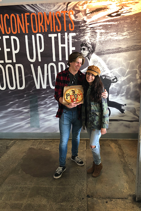 boy holding pizza spells prom at blaze pizza for his promposal